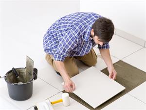 Shutterstock_67121401_man laying tile_vīrietis liek flīzes.jpg